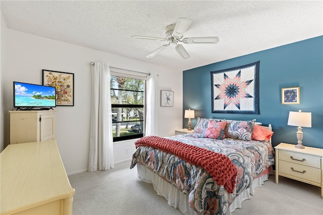 carpeted bedroom featuring a textured ceiling and ceiling fan