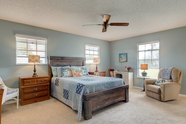 carpeted bedroom with multiple windows, ceiling fan, and a textured ceiling