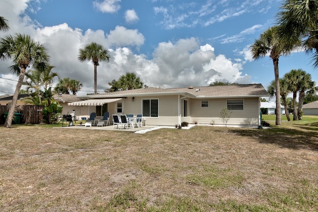 rear view of property featuring a lawn and a patio