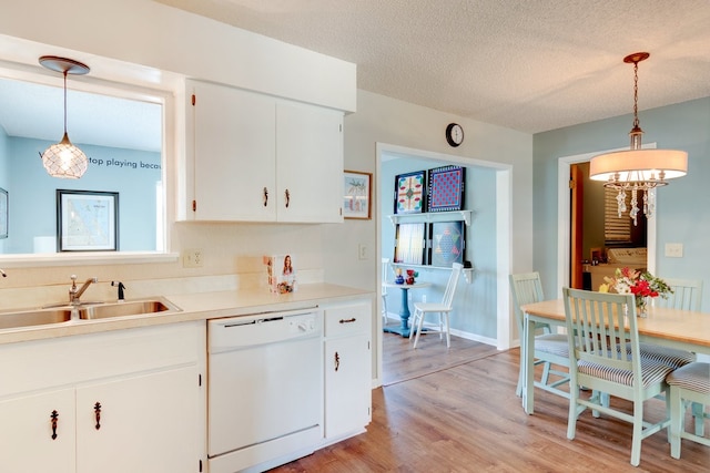 kitchen with light wood-type flooring, white cabinets, sink, dishwasher, and hanging light fixtures