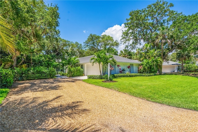 single story home featuring a garage and a front yard