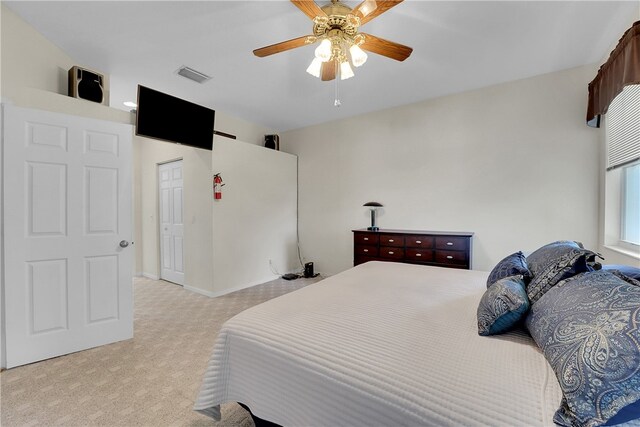 carpeted bedroom featuring ceiling fan and a closet