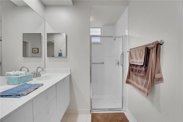 bathroom with walk in shower, vanity, and tile patterned floors