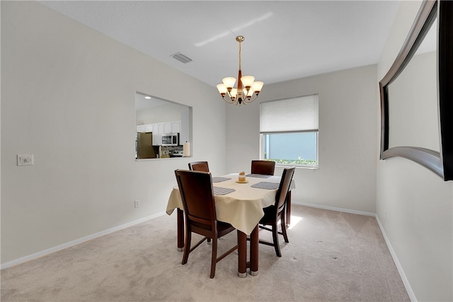 carpeted dining area featuring an inviting chandelier