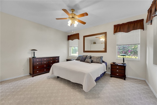 carpeted bedroom with multiple windows and ceiling fan