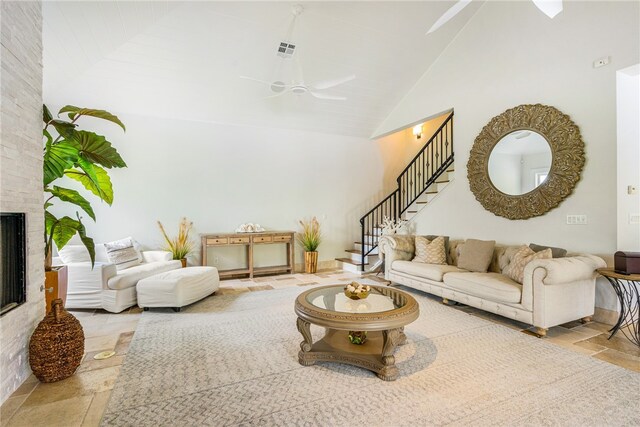 living room featuring high vaulted ceiling, a fireplace, and ceiling fan