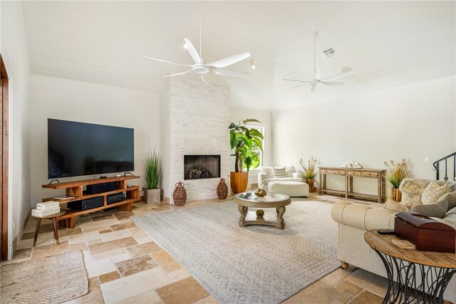 living room featuring a fireplace, ceiling fan, and high vaulted ceiling