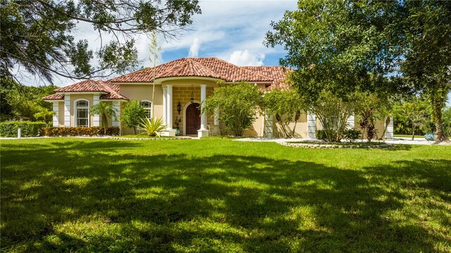 mediterranean / spanish home featuring a front lawn