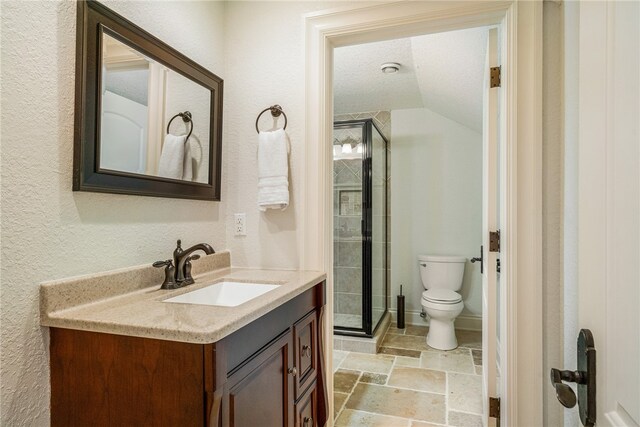 bathroom with toilet, vanity, a textured ceiling, and a shower with door