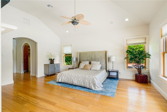 bedroom with light hardwood / wood-style floors, ceiling fan, and high vaulted ceiling