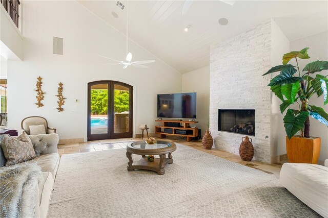 living room with high vaulted ceiling, french doors, ceiling fan, and a fireplace