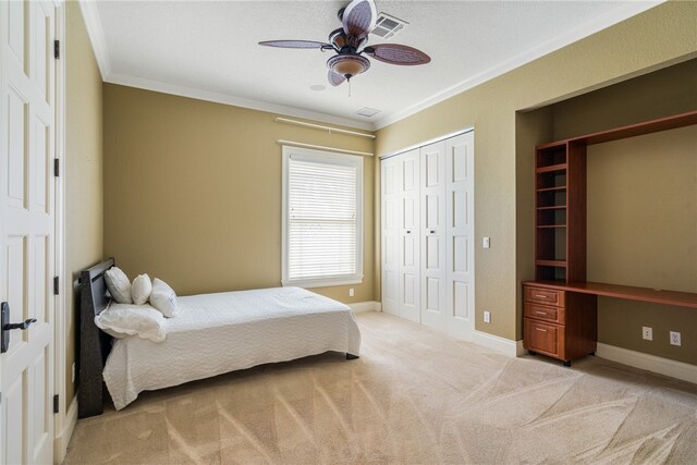 carpeted bedroom with ceiling fan and crown molding