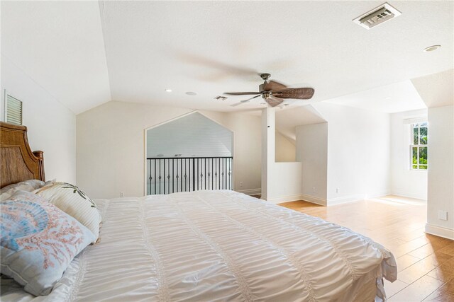 bedroom with light hardwood / wood-style floors, ceiling fan, and vaulted ceiling