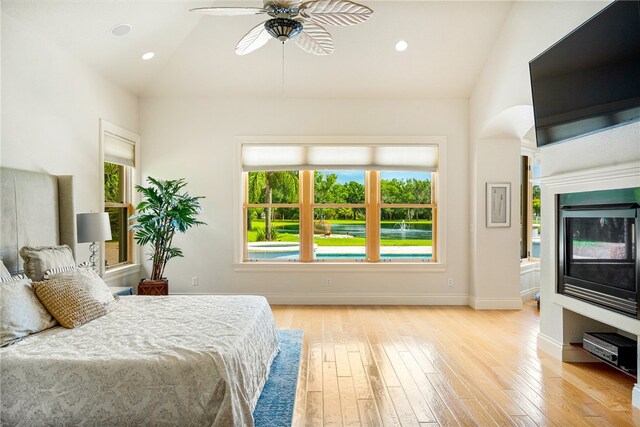 bedroom with light hardwood / wood-style flooring, lofted ceiling, and ceiling fan