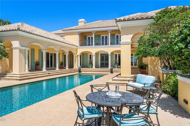 596 Ocean Rd, Vero Beach, FL 32963 - rear view of house with a chimney, a balcony, a patio, a tiled roof, and stucco siding