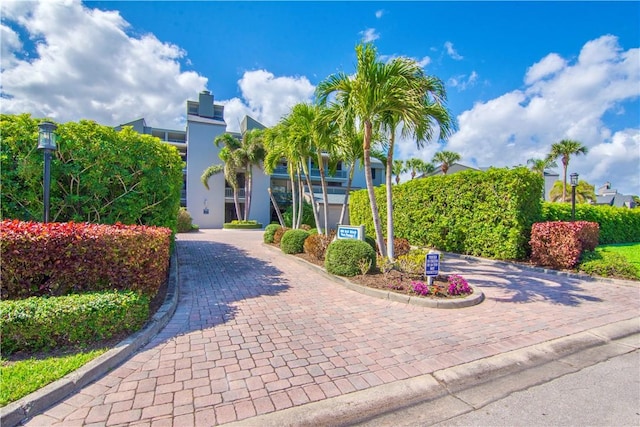 obstructed view of property with decorative driveway and stucco siding