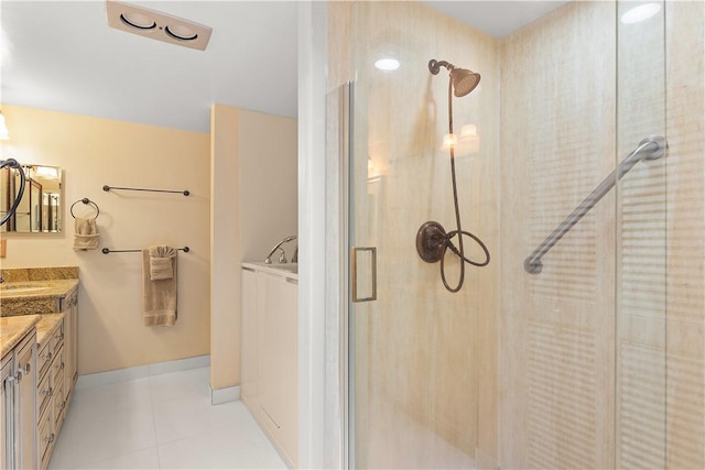 bathroom with a stall shower, tile patterned flooring, vanity, and baseboards