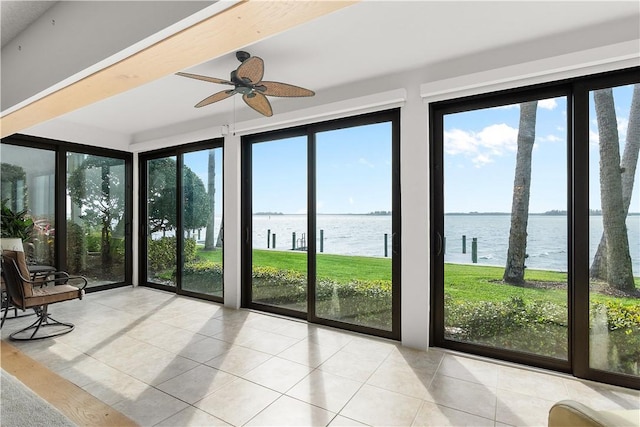 unfurnished sunroom with ceiling fan, a water view, and a wealth of natural light