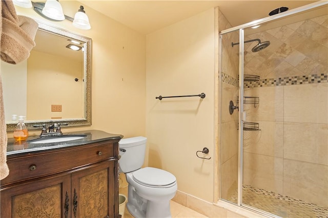 bathroom featuring toilet, a stall shower, vanity, and tile patterned floors