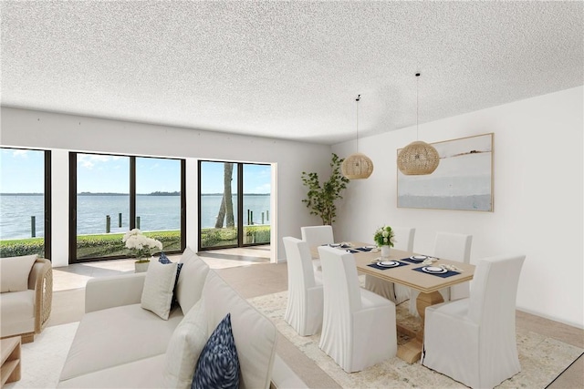 dining room with a water view and a textured ceiling