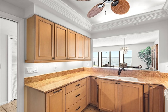 kitchen with light tile patterned floors, light stone counters, a water view, a sink, and ceiling fan with notable chandelier