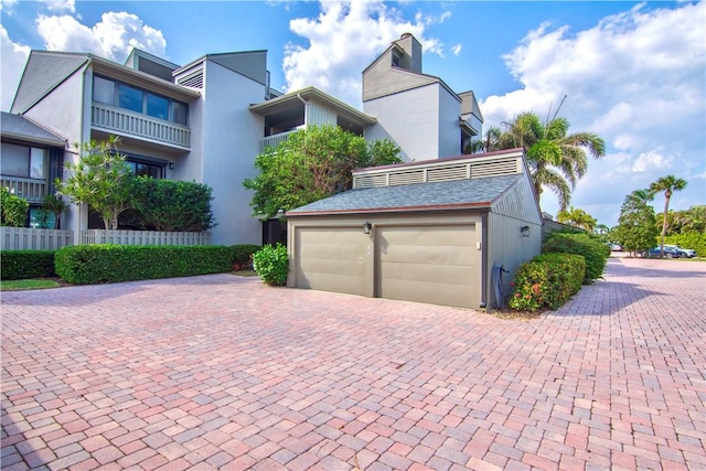 view of front facade with a garage and decorative driveway