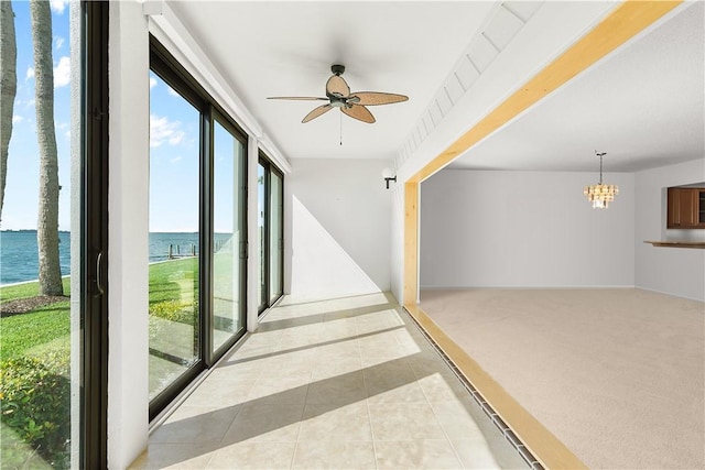 hall with light colored carpet, a wealth of natural light, a water view, and light tile patterned flooring