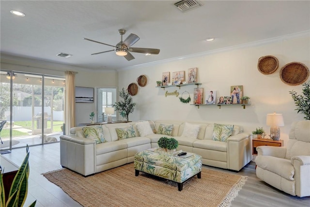 living room with crown molding, ceiling fan, and light hardwood / wood-style floors