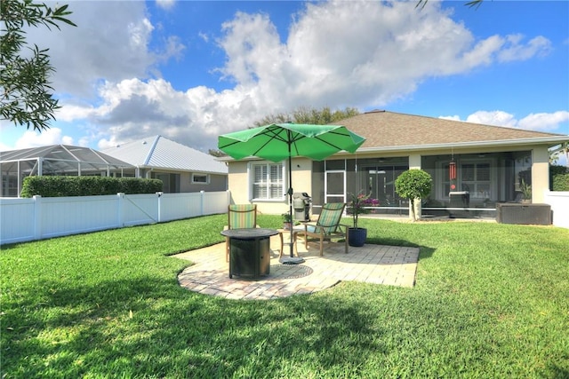 back of house featuring an outdoor fire pit, a sunroom, a patio area, and a lawn