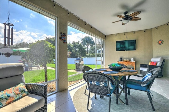 sunroom / solarium with track lighting and ceiling fan