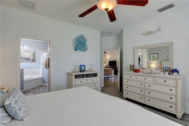 bedroom with ensuite bathroom, ceiling fan with notable chandelier, and dark hardwood / wood-style flooring