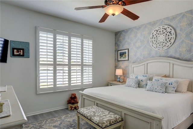 bedroom with hardwood / wood-style flooring, ceiling fan, and multiple windows