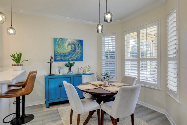 dining area featuring crown molding and light hardwood / wood-style flooring