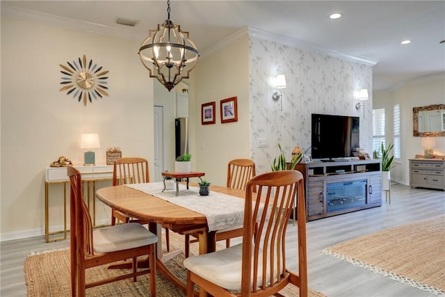 dining room with crown molding and light hardwood / wood-style flooring