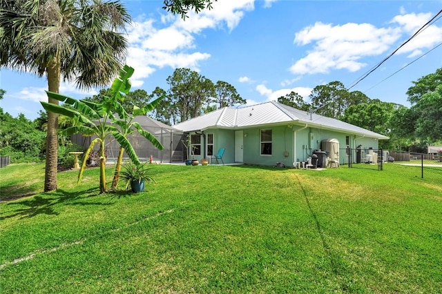 8145 95th Ct, Vero Beach, FL 32967 - rear view of property with metal roof, stucco siding, a lanai, fence, and a yard