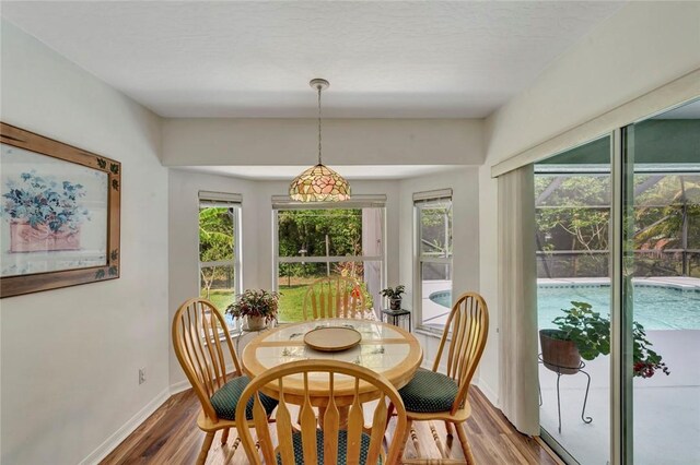 8145 95th Ct, Vero Beach, FL 32967 - dining area featuring baseboards, wood finished floors, and a healthy amount of sunlight
