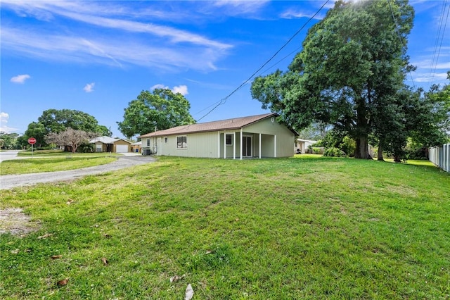 2906 1st St, Vero Beach, FL 32968 - back of property featuring a yard, fence, and aphalt driveway