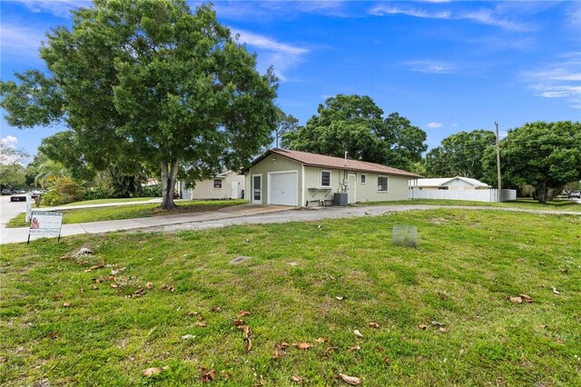 2906 1st St, Vero Beach, FL 32968 - view of front of property featuring driveway, fence, an attached garage, and a front lawn