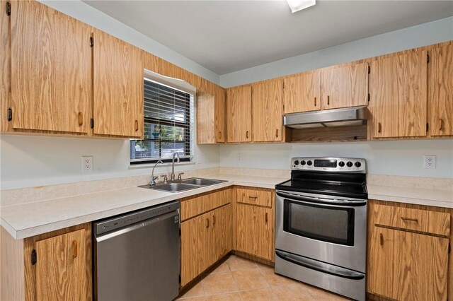 2906 1st St, Vero Beach, FL 32968 - kitchen featuring light countertops, light tile patterned flooring, under cabinet range hood, appliances with stainless steel finishes, and a sink