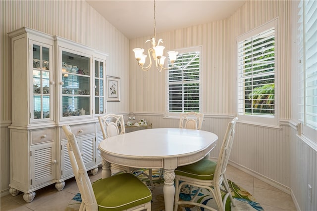 tiled dining room featuring a chandelier