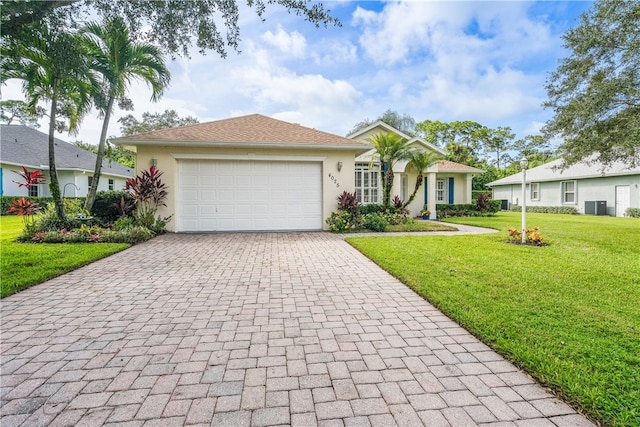 single story home featuring a garage, cooling unit, and a front yard