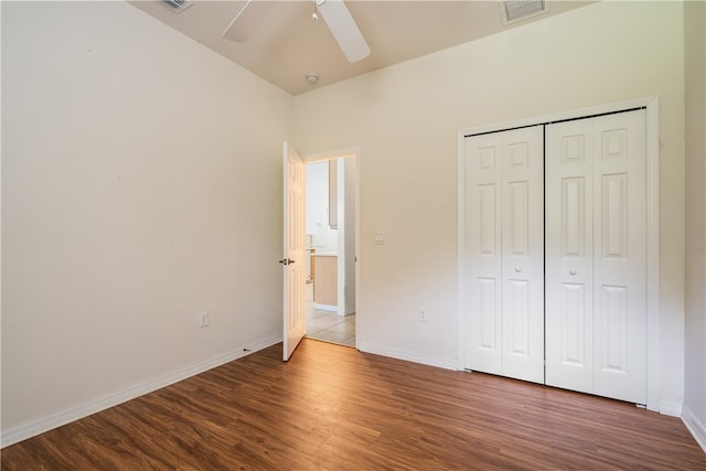 unfurnished bedroom featuring a closet, hardwood / wood-style floors, and ceiling fan