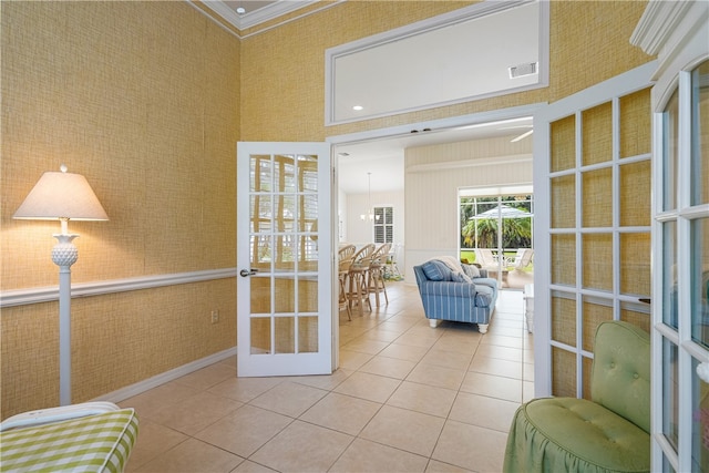 interior space with french doors, light tile patterned floors, and crown molding