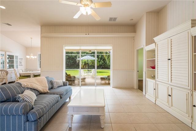 tiled living room with ceiling fan with notable chandelier