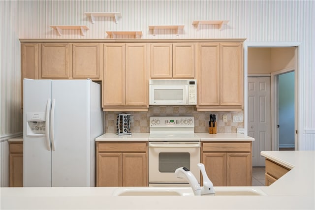 kitchen with tasteful backsplash, light brown cabinets, white appliances, and sink