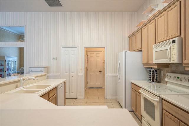 kitchen with light tile patterned floors, white appliances, and sink