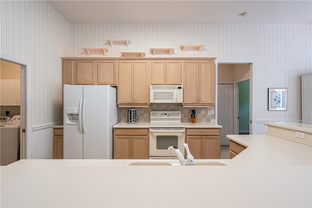 kitchen with sink, washing machine and clothes dryer, backsplash, light brown cabinets, and white appliances