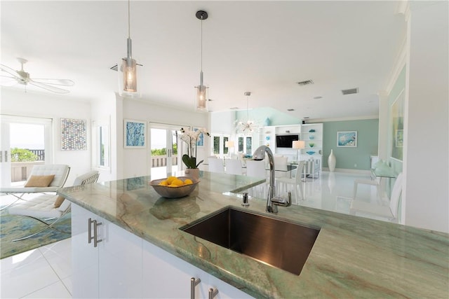 116 Ocean Way, Vero Beach, FL 32963 - kitchen featuring open floor plan, light stone countertops, tile patterned flooring, ornamental molding, and decorative light fixtures