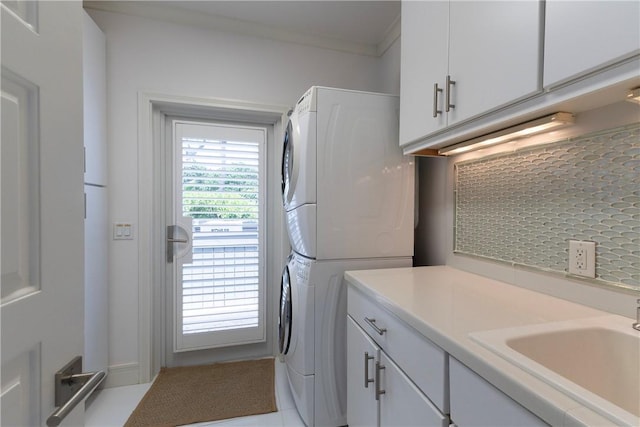 116 Ocean Way, Vero Beach, FL 32963 - laundry area with estacked washer and dryer, cabinet space, and crown molding