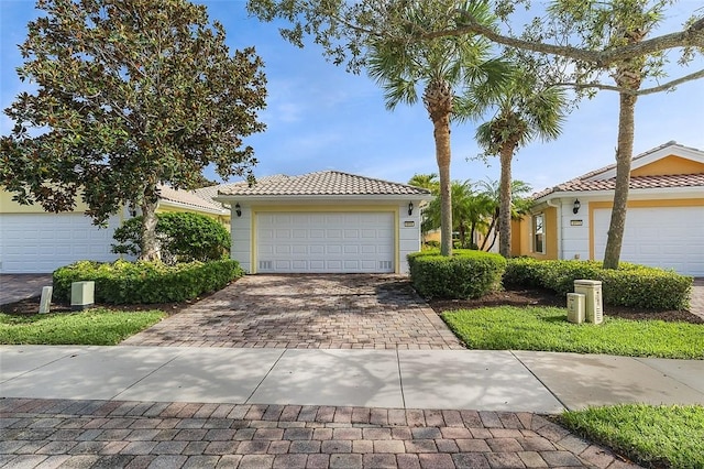 4951 Corsica Sq, Vero Beach, FL 32967 - view of front of house featuring a tile roof, a garage, decorative driveway, and stucco siding